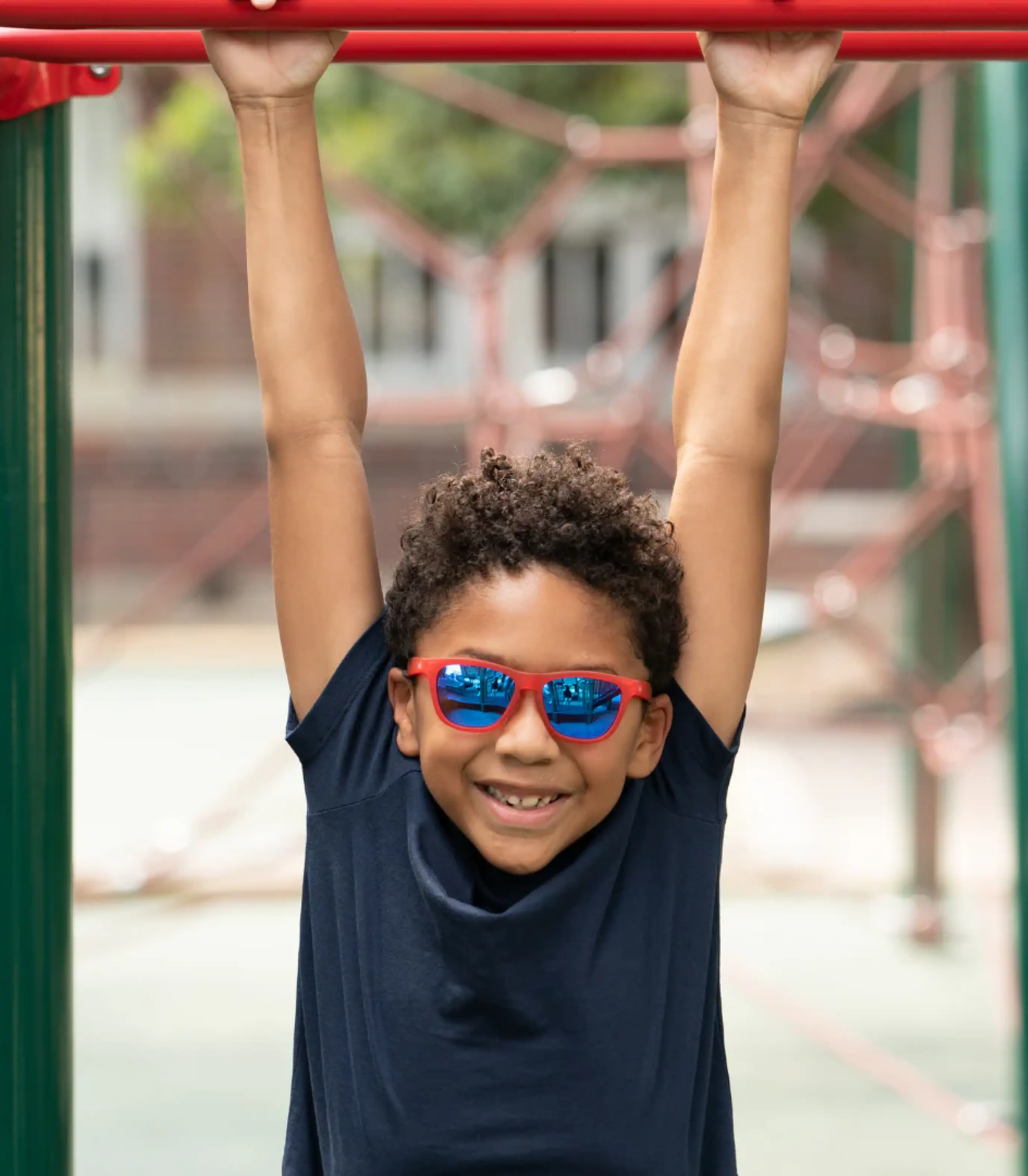 Young boy with dark rectangular sunglasses and baseball cap